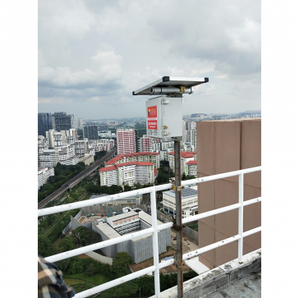AIS Noise Monitoring System mounted on pole at highrise construction site, Singapore skyline