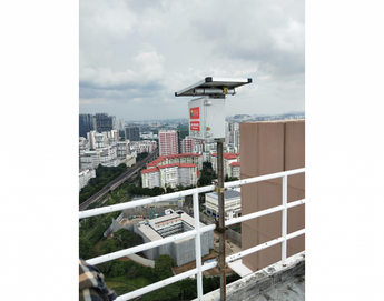 AIS Noise Monitoring System mounted on pole at highrise construction site, Singapore skyline